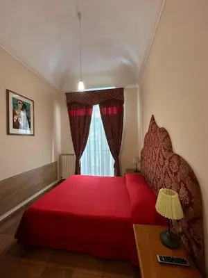 a bedroom with a red bed and a window at Alloggio Turistico in Rome