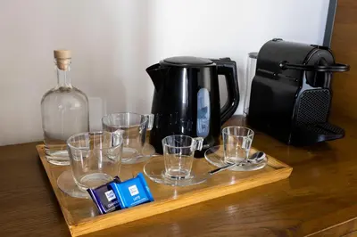 a wooden tray with glasses and a bottle on a table at Alla Corte Guest House by Hili in Rome