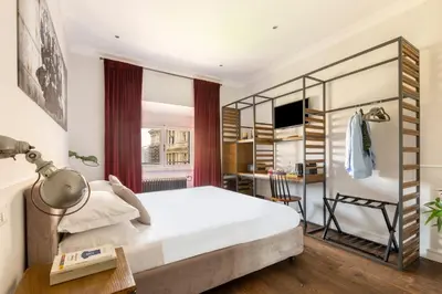 a bedroom with a bed and a desk with a chair at Alla Corte Guest House by Hili in Rome