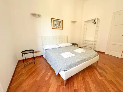a bedroom with a bed and a wooden floor at Montezebio Boutique Apartment in Rome