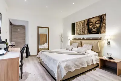 a bedroom with a large bed with a painting on the wall at Relais Colonna in Rome