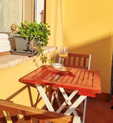 a wooden table with a glass of wine and a plant at Domus Cornelia in Rome