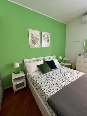 a bedroom with a large bed with green walls at Domus76 Casa Vacanze in Rome