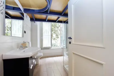 a bathroom with a white sink and a blue ceiling at Vatican Holiday Home in Rome