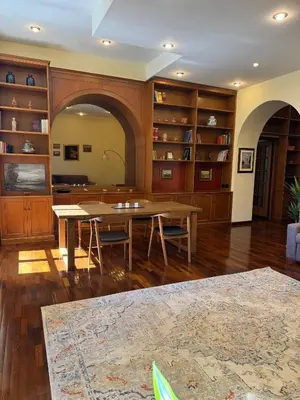 a living room with a table and chairs and shelves at Colosseum's Custodian - Apartment 115 m2 in Rome