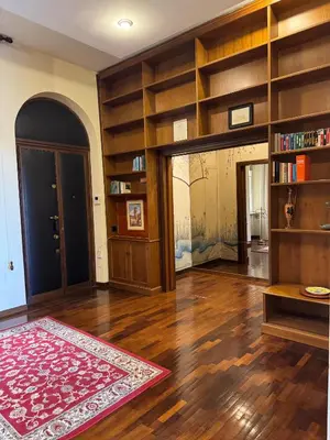 a living room with wooden shelves and a door at Colosseum's Custodian - Apartment 115 m2 in Rome
