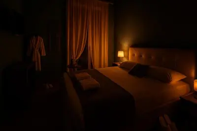 a dark room with a large bed with two lamps at Roma Design Rooms San Giovanni Colosseo Area in Rome