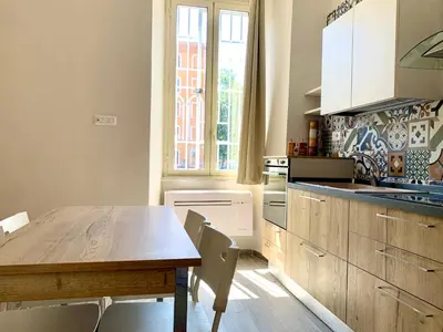 a kitchen with a wooden table and a wooden table and chairs at Casa Minerva a Testaccio in Rome