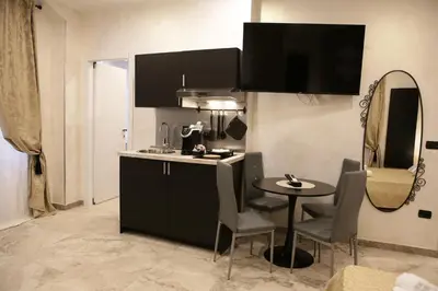 a kitchen with a small table and a mirror at Jadore Monic in Rome