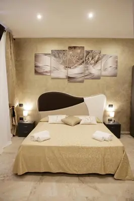 a bedroom with a large bed with three paintings on the wall at Jadore Monic in Rome