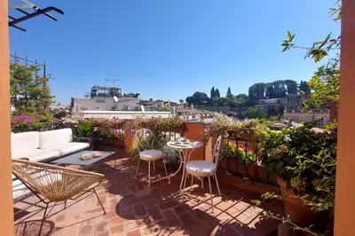 a patio with a couch and chairs on a balcony at Rooftop SUITE - FORO ROMANO LUX in Rome