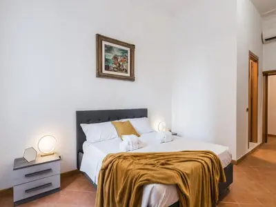 a bedroom with a large bed with a gold blanket on it at The Best Rent - Three-bedroom apartment near the Quirinale in Rome