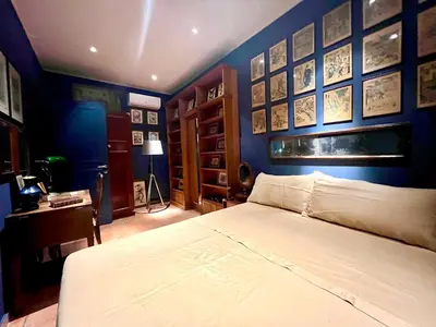 a bedroom with a blue wall with a bed and a desk at CHALET MARMONT ROME in Rome