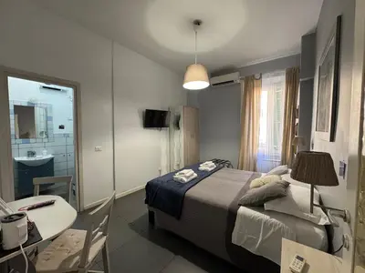 a bedroom with a bed and a desk and a sink at Le Due Civette Roma in Rome