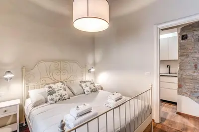 a bedroom with a large white bed with a light fixture at Vicolo leopardo suite Trastevere in Rome