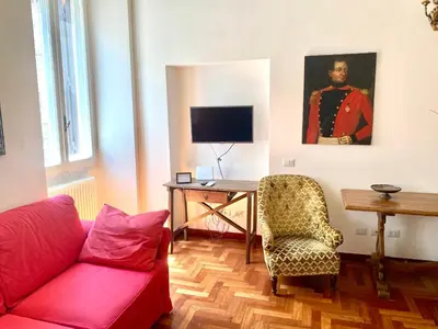 a living room with a red couch and a desk at Quirinale Suite Fontane in Rome