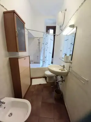 a bathroom with a sink and a toilet and a mirror at la casa del viaggiante in Rome