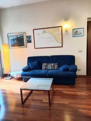 a living room with a blue couch and a coffee table at la casa del viaggiante in Rome