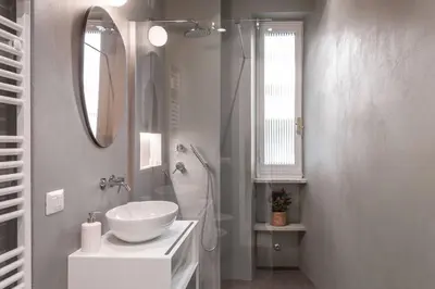 a white bathroom with a sink and a mirror at laDolceVita - Flaminio Stylish Flat in Rome