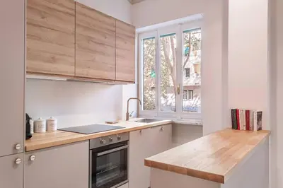 a kitchen with white cabinets and a sink and a window at laDolceVita - Flaminio Stylish Flat in Rome