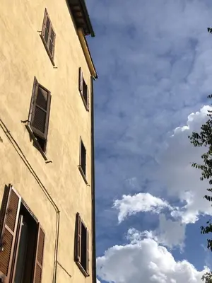 a building with windows and a blue sky with clouds at All'antico molino in Rome