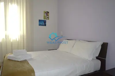 a bedroom with a bed with white sheets and pillows at Your Roman Retreat near San Giovanni in Rome