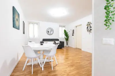 a dining room and living room with a white table and chairs at Mosaic Trastevere Silver Apartment in Rome