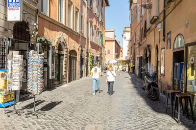 a couple of people walking down a street at Mosaic Trastevere Silver Apartment in Rome