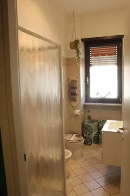 a bathroom with a shower and a toilet and a window at Capital House Roma in Rome