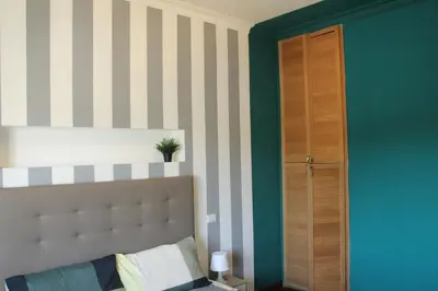 a bedroom with a bed and a green wall at Capital House Roma in Rome