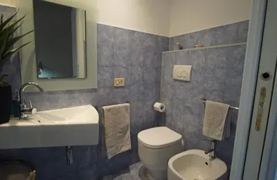 a bathroom with a white toilet and a sink at Dimora Qeeboo in Rome