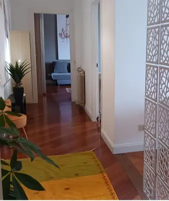 a hallway with a living room with a hard wood floor at Dimora Qeeboo in Rome