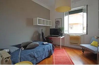 a bedroom with a bed and a desk with a computer at Dimora Qeeboo in Rome
