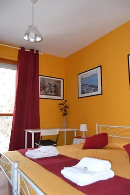 a bedroom with a large bed with yellow walls at LunaBed Roma - Affitti brevi in Rome