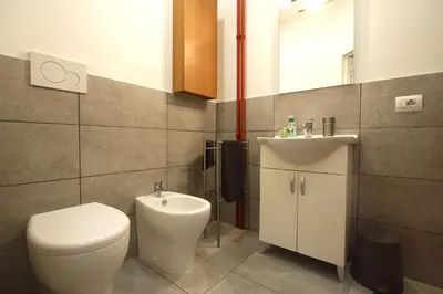 a bathroom with a toilet and a sink at Fabiola Holiday House in Rome
