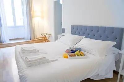 a white bed with a tray of food on it at APT Rome 5 BDRMs in Rome