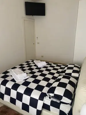 a black and white checkered bed in a room at Nic Roma House in Rome
