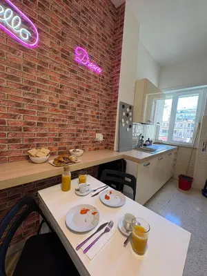 a kitchen with a table and a brick wall at Domus Oriana in Rome