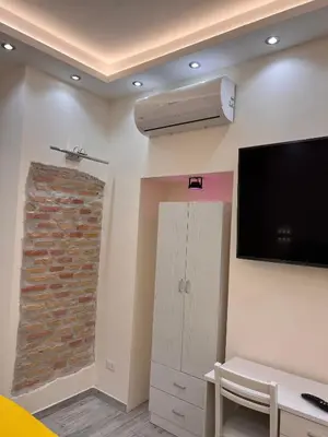 a living room with a flat screen tv and a wall at IMPERIUM INN in Rome