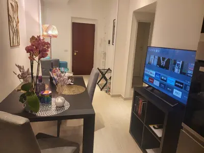 a living room with a table and a flat screen tv at Vatican Tolemaide 2 Suites 2 Bagni in Rome