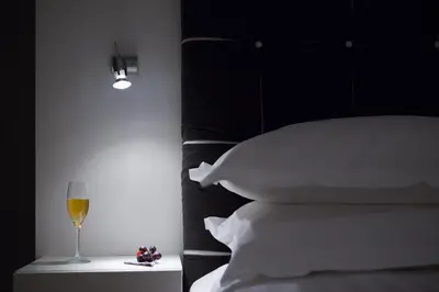 a bedroom with a bed with a glass of wine at Melody Suite Rome in Rome