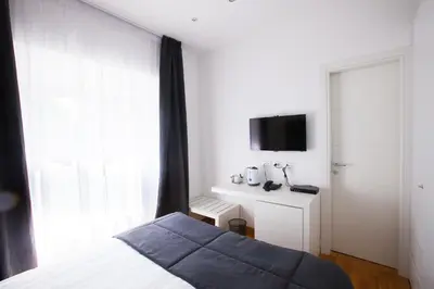 a bedroom with a bed and a tv on a wall at Melody Suite Rome in Rome