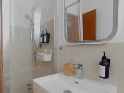 a bathroom with a sink and a mirror and a shower at Policlinico Apartment in Rome