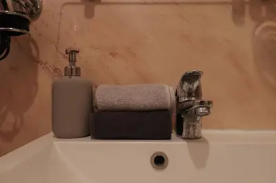 a bathroom sink with a soap dispenser and a towel at [Termini Treasure] - Elegant retreat in Rome