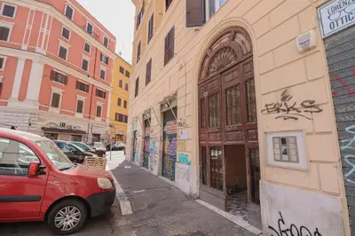 a red car parked on a city street with buildings at [Termini Treasure] - Elegant retreat in Rome