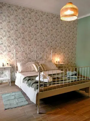 a bedroom with a bed and a wall covered in wallpaper at The green place alloggio turistico in Rome