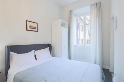 a white bed in a white bedroom with a window at Prefetti 46 in Rome