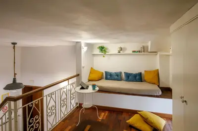 a room with a bed with yellow and blue pillows at B5 Apartment Vatican in Rome