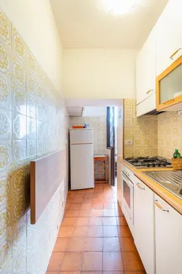 a kitchen with white cabinets and a tile floor at Accogliente casa a due passi da Piazza Navona in Rome