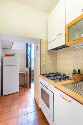 a kitchen with white appliances and a tile floor at Accogliente casa a due passi da Piazza Navona in Rome